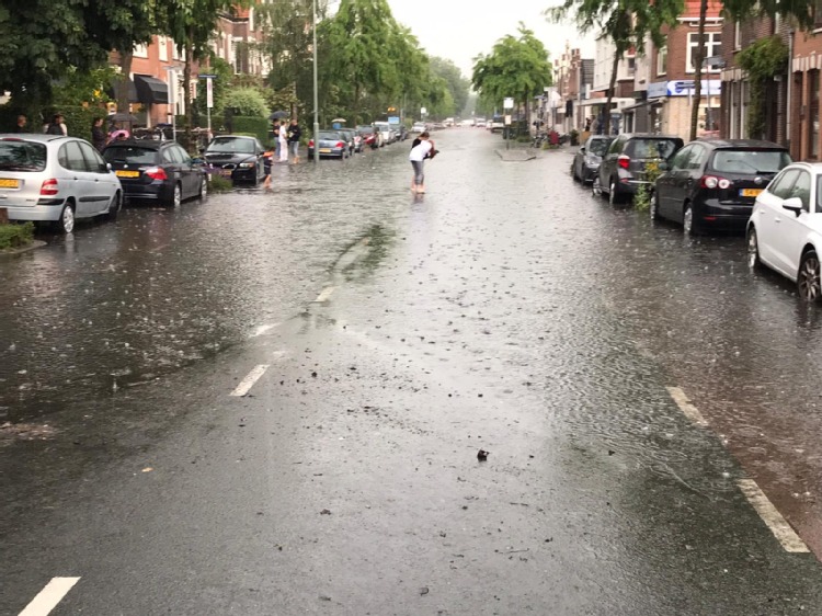 Fikse regenbui doet Reeweg Oost onder water lopen